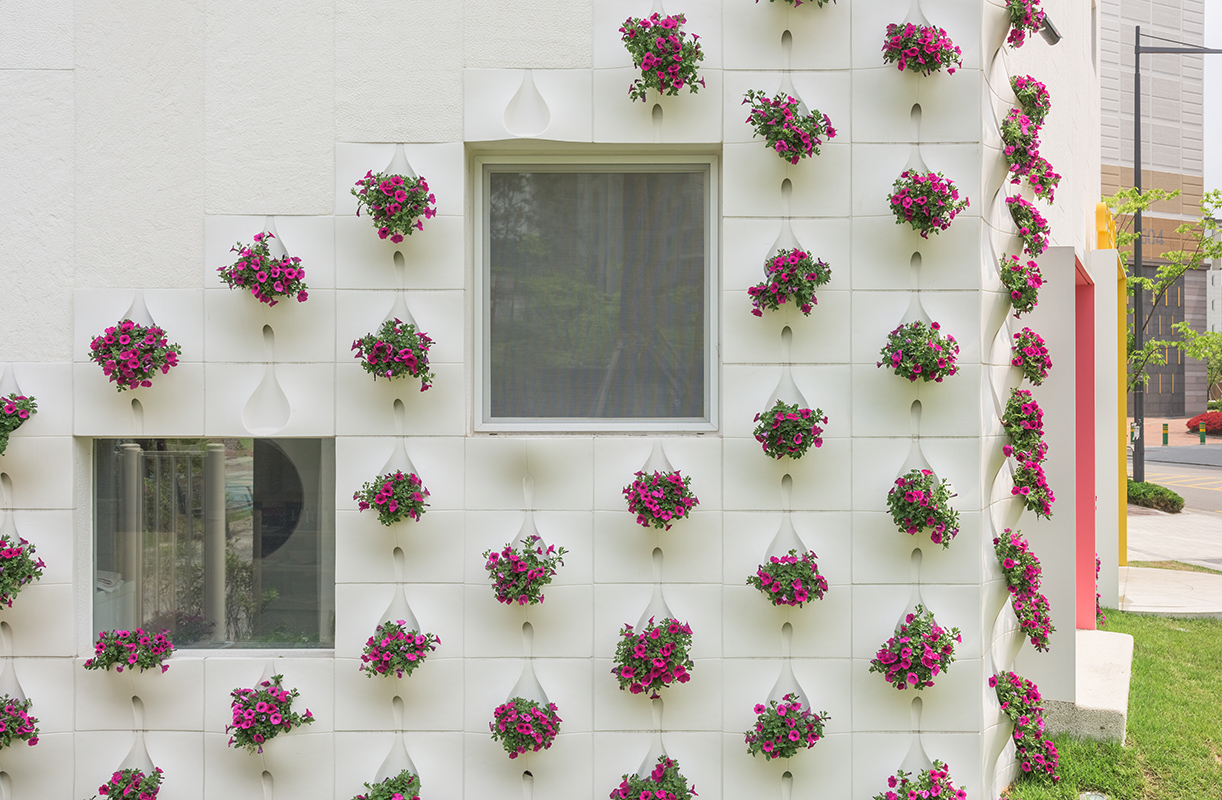 Саксии за цветя, вградени във фасадата на жилищна сграда