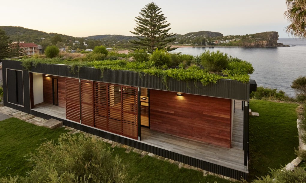 Къща със зелен покрив и панорамна гледка към океана