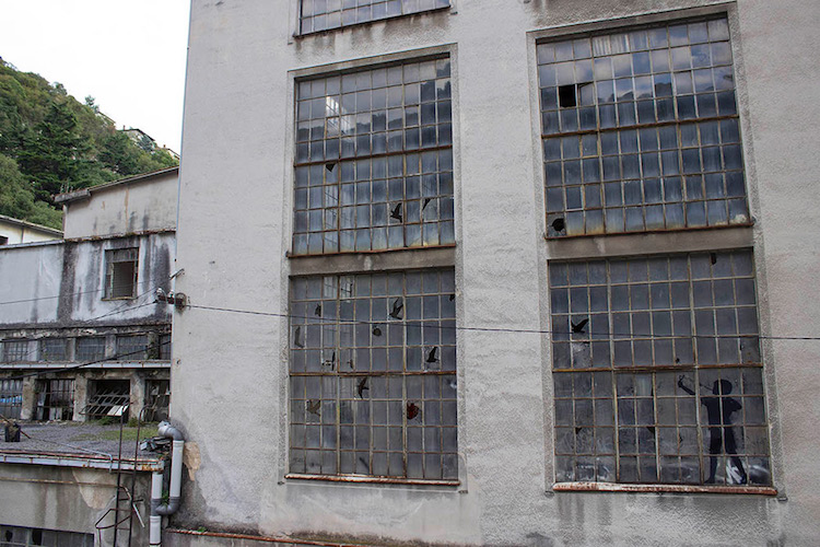 Прозорци на изоставена фабрика, изрязани във формата на птици